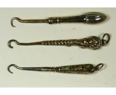 A small all silver button hook with decorative scroll handle and two other small silver button hooks (3)
