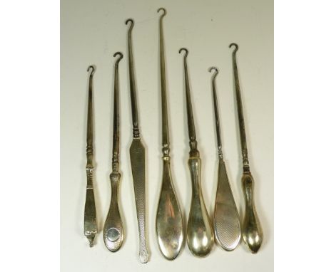 Seven silver handled button hooks, some with guilloche decoration (7)