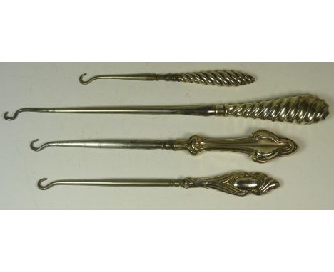 A Victorian button hook with spiral groove silver handle; another smaller and two others with silver handles (4)