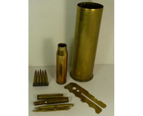 An 18 pounder brass shell case; a small brass shell case; two "bullet" pens; a similar cigarette lighter; a clip of 5 bullets