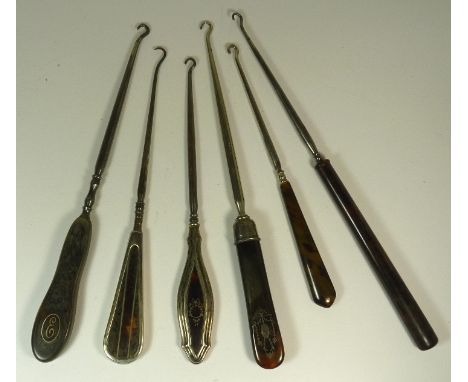 An early 20th Century tortoiseshell and silver button hook the handle with silver inset cartouche and ribbon tie garland deco