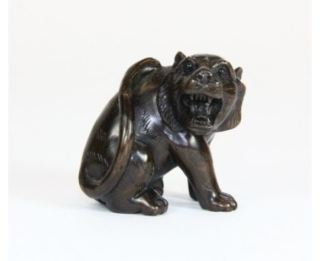 A carved hardwood netsuke of a tiger