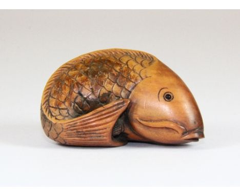 A signed carved fruitwood netsuke of a carp with black onyx eyes
