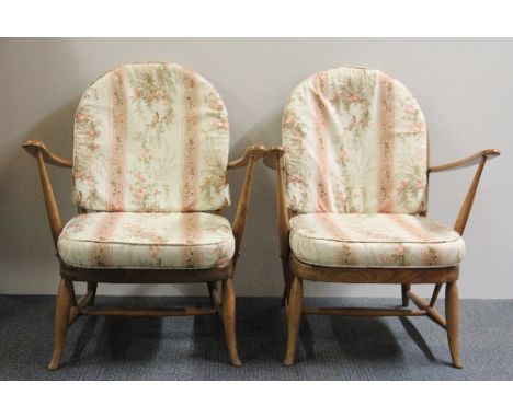 A pair of low Ercol cottage chairs with loose cushions