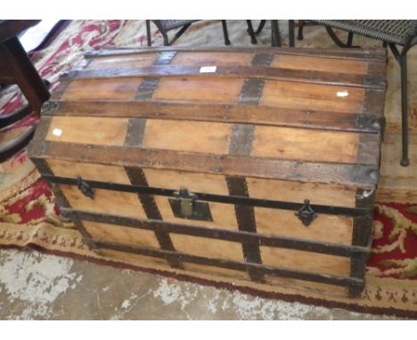 A 19th century stripped pine and metal-bound dome top cabin trunk
