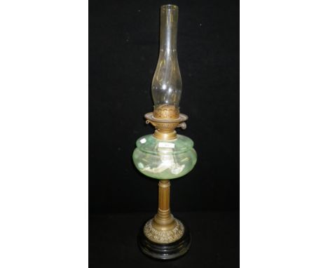 An Edwardian glass oil lamp on brass column and black ceramic foot
