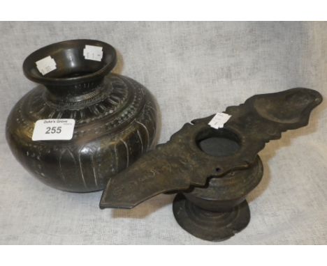 A Persian brass and copper pot with all over hammered decoration and an oil lamp