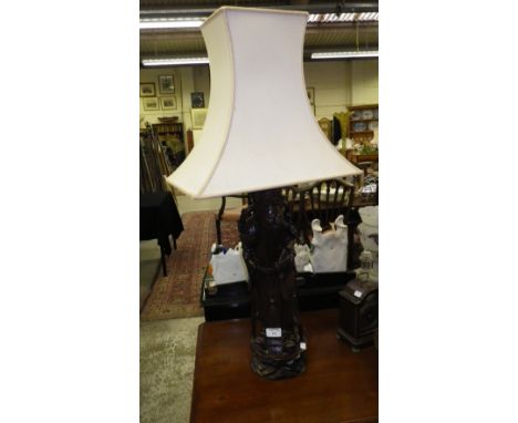 An Oriental carved figure converted to a table lamp