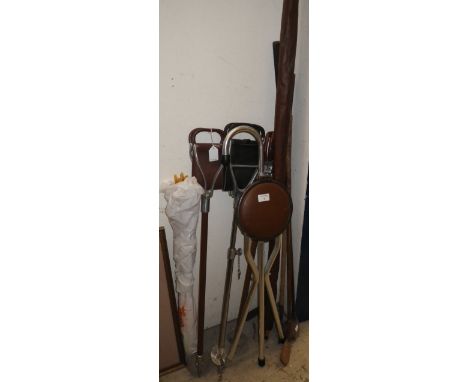 A collection of shooting sticks, a bow with arrows and a quantity of vintage golf clubs