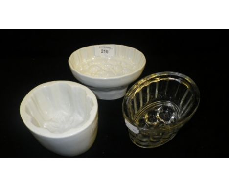 Two white glazed ceramic jelly moulds and a similar glass mould