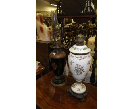 A Victorian glass oil lamp decorate with flowers and a Gothic ebonised and brass oil lamp