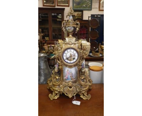 A 19th century spelter mantel clock with inset ceramic panel decorated with a couple in 18th century costume