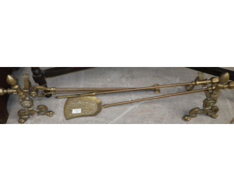 A set of brass fireplace tools with matching dogs