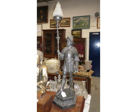 An early 20th century spelter table lamp in the form of a warrior with a glass flame shade