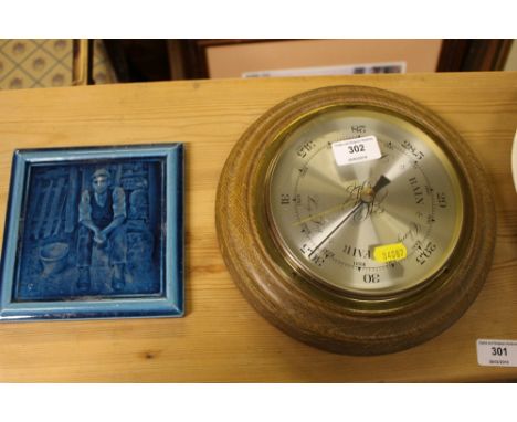 An oak barometer and a turquoise glazed tile 