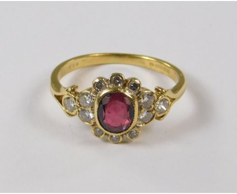 RUBY RING. An 18ct. gold ruby &amp; diamond cluster ring. Size M/N.