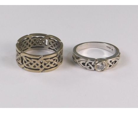 GOLD RINGS. An 18ct. white gold, Celtic strap work ring &amp; an 18ct. gold dress ring, set a solitaire diamond. Size M &amp;