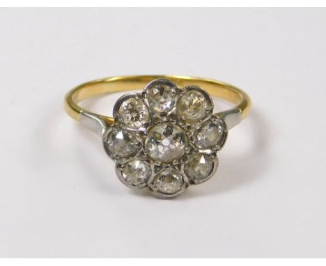 DIAMOND RING. An 18ct. gold, old brilliant cut, diamond flowerhead ring. Face 11mm. Size L.