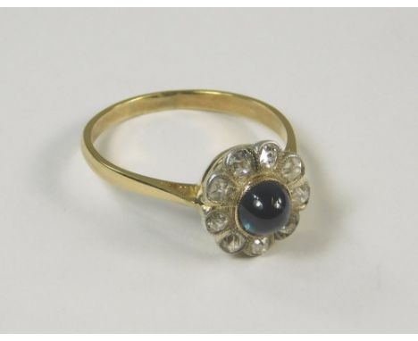 SAPPHIRE RING. An 18ct. gold cabouchon sapphire and diamond flowerhead ring. Size R.