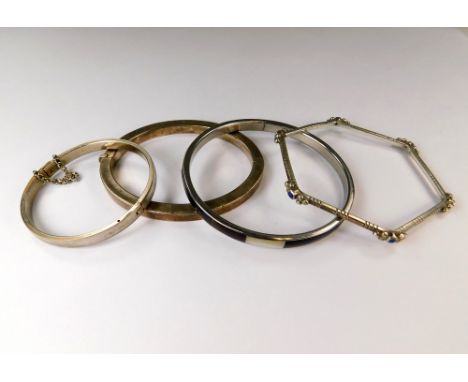 BANGLES. An oval hinged silver bangle &amp; three other white metal bangles.