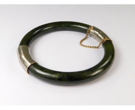 JADE BANGLE. A gilt metal mounted spinach jade bade bangle.