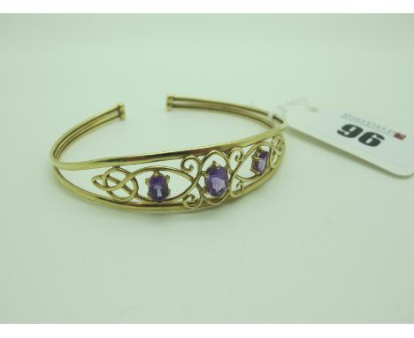 A Decorative Openwork Bangle, oval claw set. 