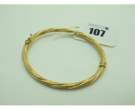 A Modern Hinged Bangle, of textured finish (sprung hinge) stamped "375" (4.7grams). 