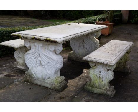 A CAST RECONSTITUTED STONE RECTANGULAR GARDEN TABLE the end supports in the form of winged rams and the moulded edge of the t