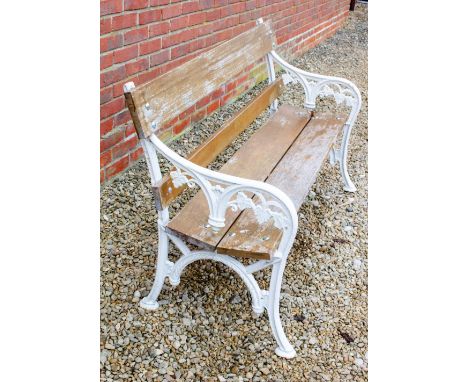 A VICTORIAN WHITE PAINTED CAST IRON GARDEN BENCH with foliate cast ends and wooden back and seat, 137cm wide x 58cm deep x 82