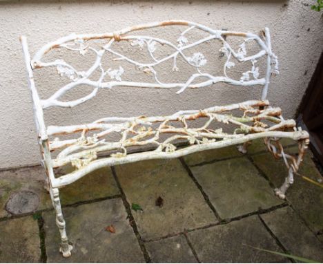 A WHITE PAINTED CAST IRON BENCH of naturalistic form with rope tied oak branches, 135cm wide x 89cm high Condition: one arm l