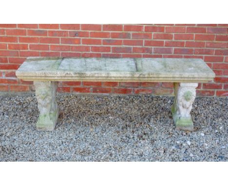 A COMPOSITE STONE GARDEN BENCH with seated lion supports, 168cm long x 46cm deep x 59cm high Condition: minor surface marks