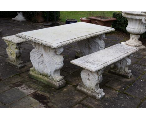 A CAST RECONSTITUTED STONE RECTANGULAR GARDEN TABLE the end supports decorated with pairs of winged rams and with egg and dar