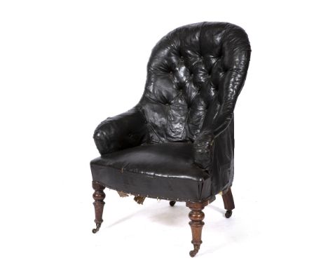 A VICTORIAN ARMCHAIR with black leatherette upholstery, button back and arms, turned tapering front legs terminating in caste
