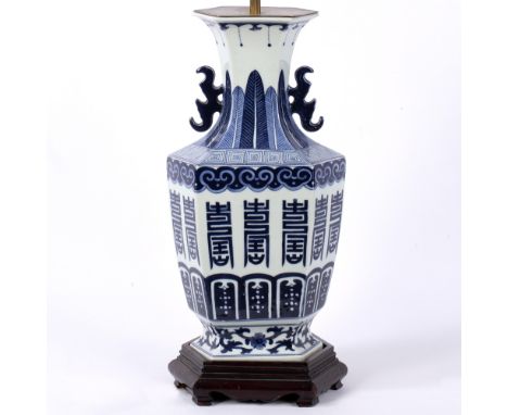 A 17TH CENTURY STYLE BLUE AND WHITE CHINESE PORCELAIN HEXAGONAL BALUSTER TABLE LAMP with wooden base and pierced handles, 21c