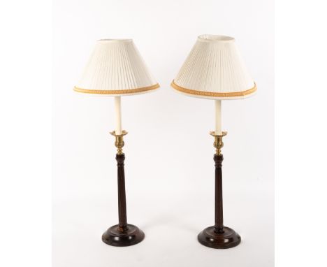 A PAIR OF GEORGIAN STYLE MAHOGANY AND BRASS TABLE LAMPS with circular spreading bases and fluted column supports, the bases 1