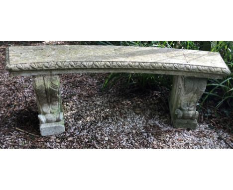 A CURVING GARDEN BENCH with scroll supports and egg and dart moulded edge, reconstituted stone, 148cm wide x 48cm high Condit
