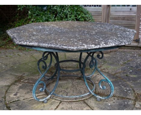 AN OCTAGONAL GARDEN TABLE with reconstituted stone top and scrolling wrought iron base, the top 135cm wide x 73cm high Condit