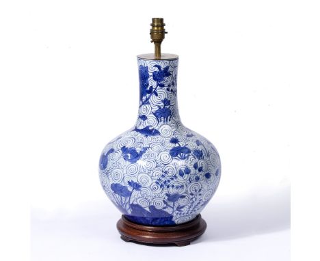 A BLUE AND WHITE PORCELAIN BALUSTER SHAPED TABLE LAMP decorated with fish, lilies, birds and scrolling waves, all on a turned