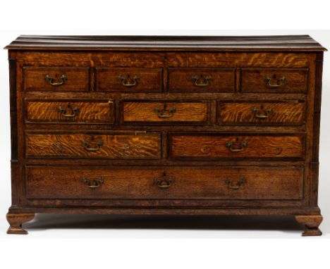 A GEORGE III OAK MULE CHEST with a lifting top, four faux drawers, three short drawers, two long drawers and a full length dr