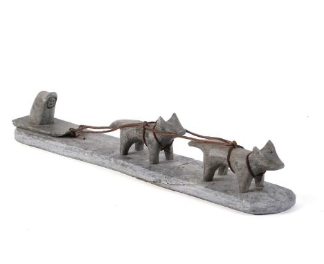 A 20th Century Inuit stone carving, formed as a stylised dog sled group, with leather harness, impressed mark to underside, 3