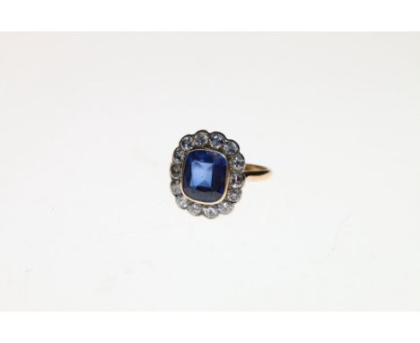 18ct gold sapphire and diamond ring, the sapphire approximately 10mm x 8mm encircled by twelve small round diamonds approxima