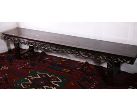 Late 19th or early 20th century Chinese hardwood low long table the pierced frieze carved with peaches and scrolling foliage,