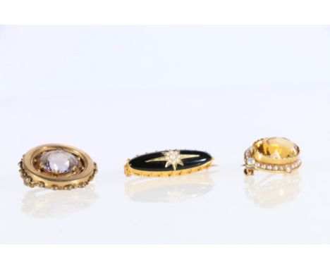 Three Victorian yellow metal brooches including a citrine and seed pearl brooch, amethyst set circular target brooch and a se