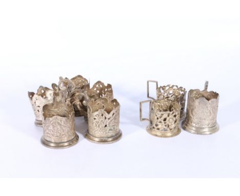 Set of five Iranian white metal coffee can or glass sleeves, pierced and decorated with figures, another pair with animal bir