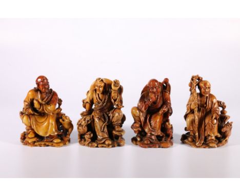 Set of four 20th Century Chinese soapstone carvings depicting seated Buddhist figures each with an animal beside them and dre