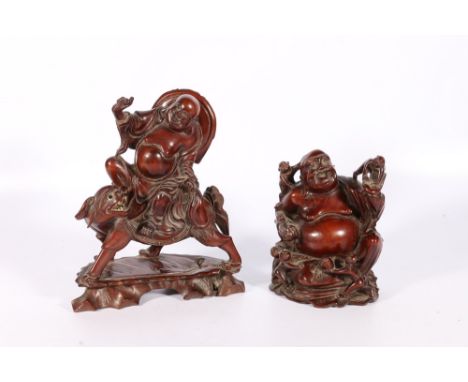Two Chinese mid 20th century carved hardwood figures of Pu Tai, one riding a lion dog, the other with children climbing on hi