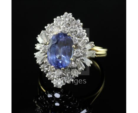 A modern 18ct gold, sapphire and diamond cluster ring, of quatrefoil shape, the oval cut sapphire surrounded but round and tr