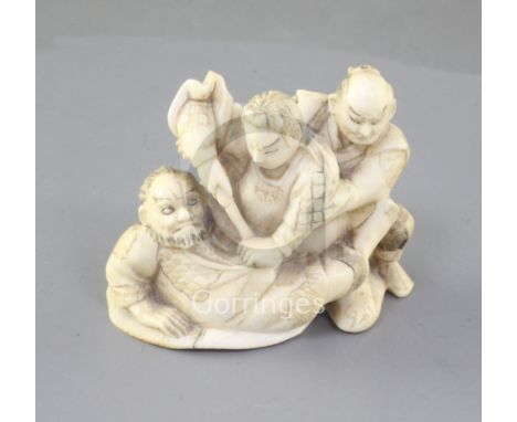 A Japanese ivory okimono netsuke of three Samurai warriors fighting, two character engraved signature to a red lacquer tablet