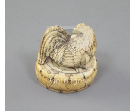 A Japanese ivory netsuke of a cockerel seated on an oval box, 19th century, the box with metal pin inlay, unsigned, 4.3cm hig