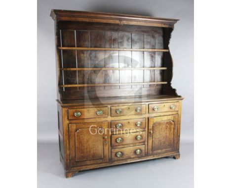 A George III oak dresser, with three shelf rack, six drawers and two panelled doors, W.5ft 10in. D.1ft 8in. H.6ft 7in.